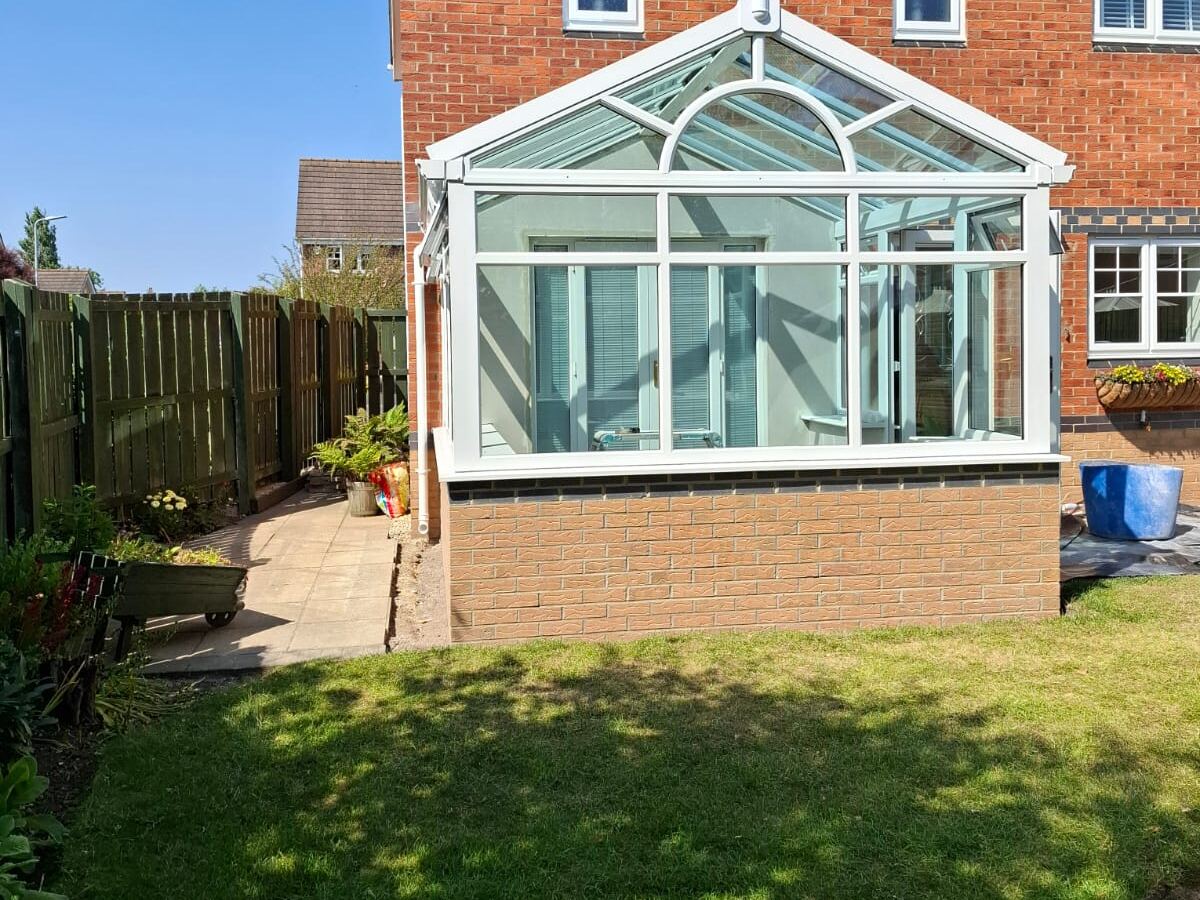 A white Edwardian style conservatory fitted by Heritage on a brick house
