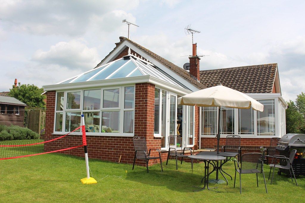 Orangery with lantern roof opening onto a patio